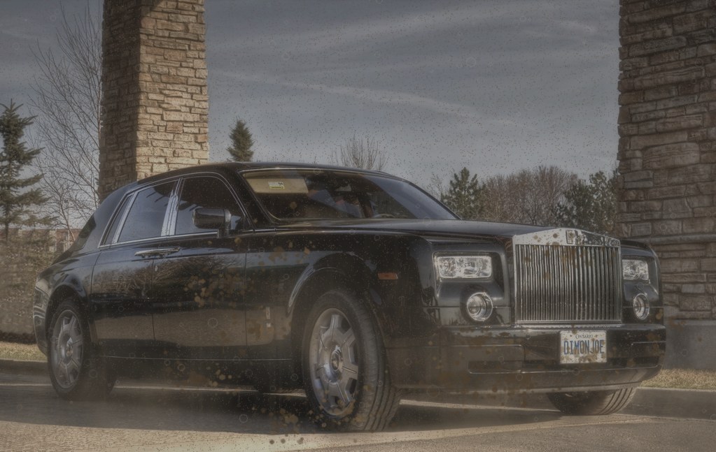 Dusty dull black luxury sedan covered in road film before a mobile exterior detail in Philadelphia